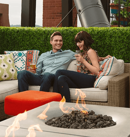 couple sitting on couch with fire pit
