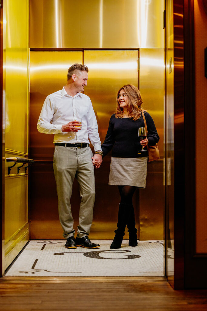 Couple holding hands in elevator of hotel 